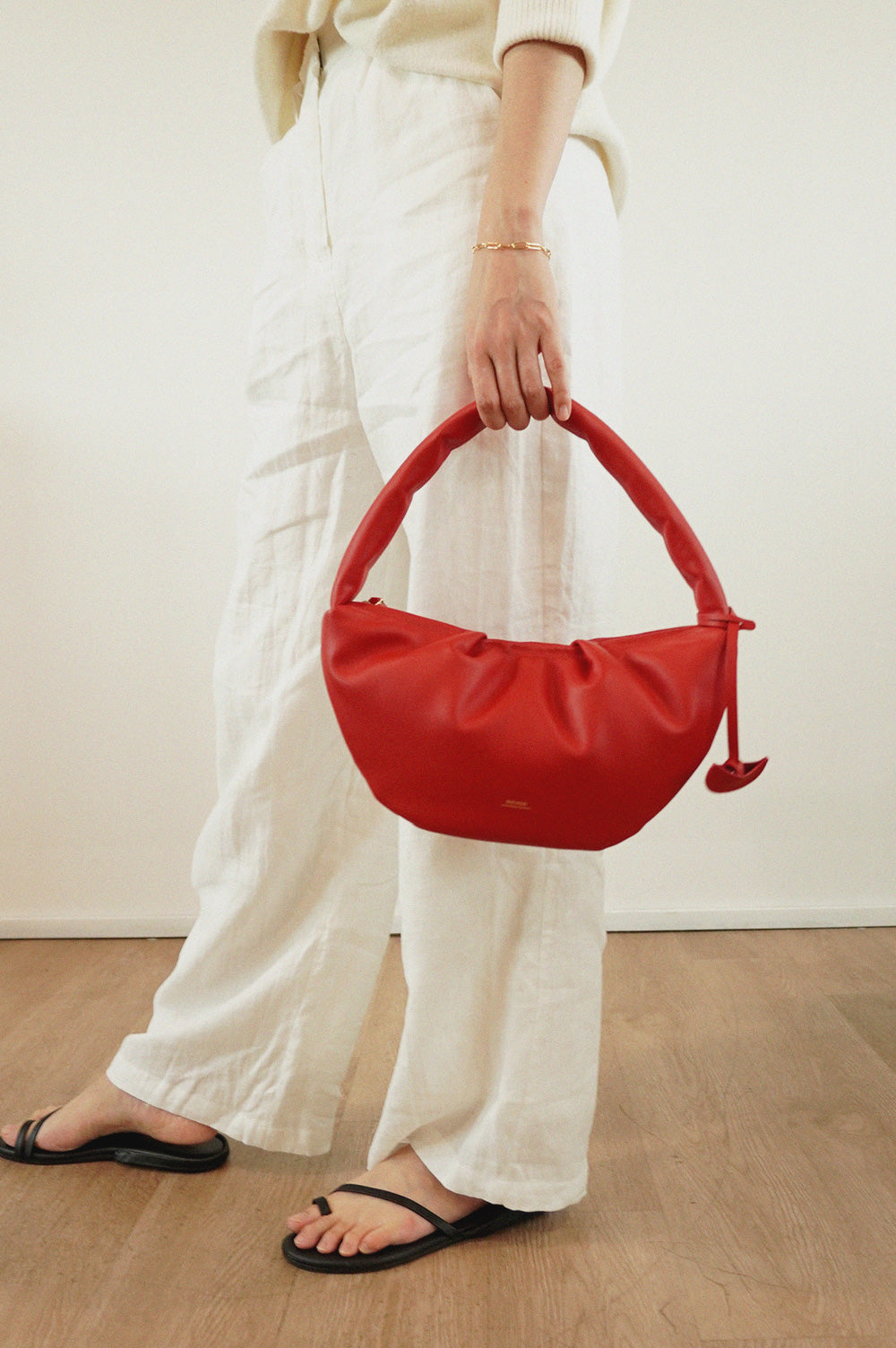 Gyoza Shoulder Puffer Bag for Women in Cherry, leather bag in Singapore, model holding by side.