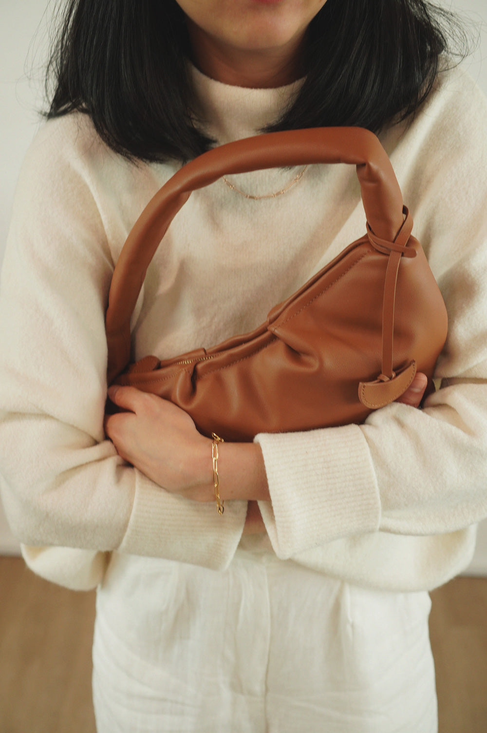 Gyoza Leather Shoulder Bag for Women in Maple, leather bag in Singapore, model holding close to body.