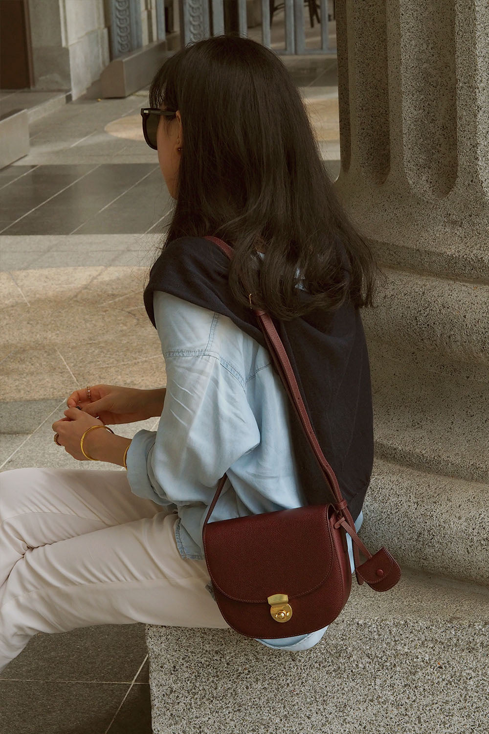 Huns Saddle Bag in Bordeaux worn as a shoulder bag, adjustable to crossbody bag.