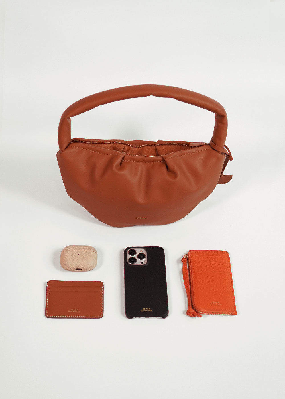 Gyoza Shoulder Bag for Women, leather bag in Singapore, essentials displayed outside to showcase capacity.