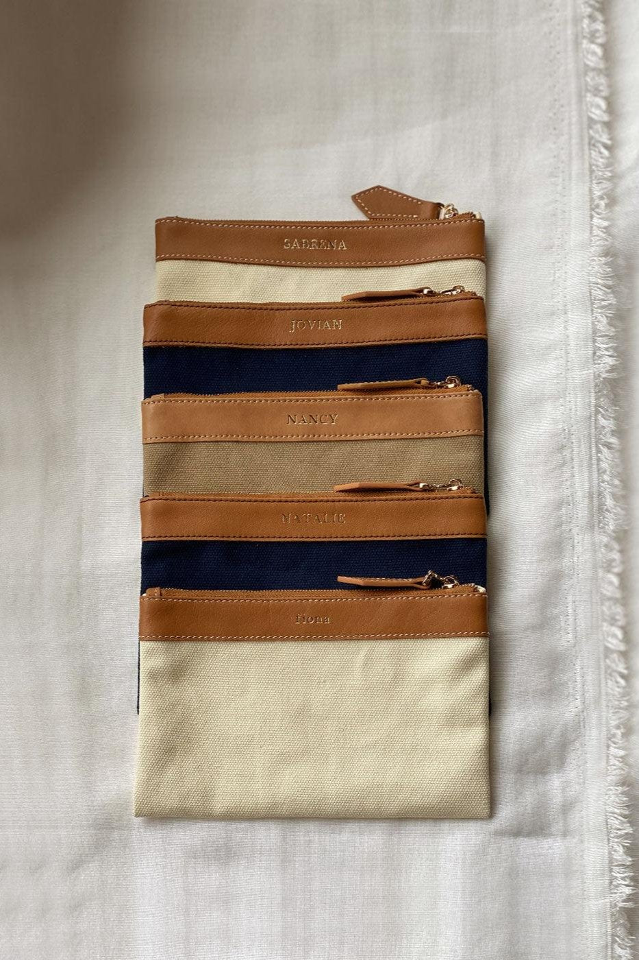 Set of 5 leather zip personalised pouches in assorted colours, customised gifts in Singapore.
